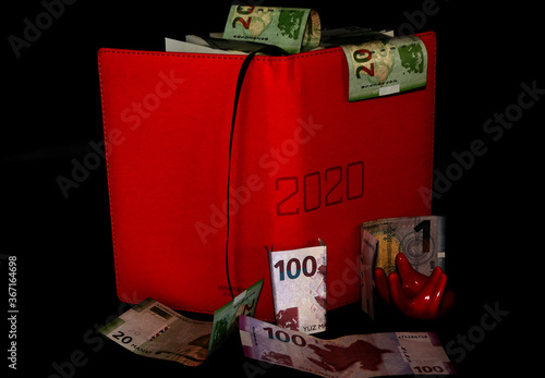 Money falling on red notebook ,AZN currency, online 2020 money photo