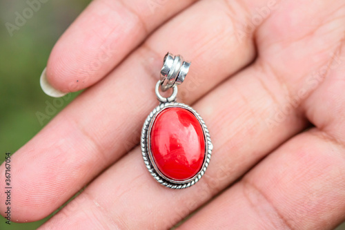 Outdoor close up of hand showing mineral gemstone oval pendant