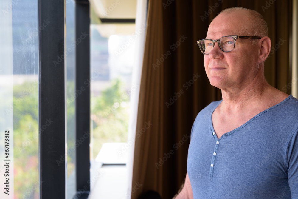 Senior handsome Scandinavian man inside the room by the window Senior handsome Scandinavian man inside the room by the window