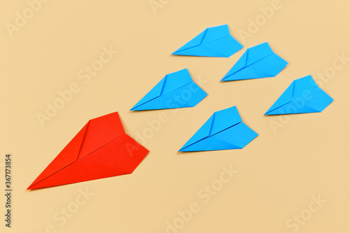 Red paper airplane leading blue airplanes. Concept for discovery and leadership