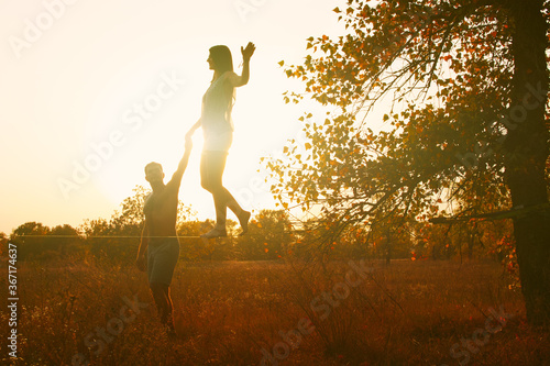 Middle age Caucasian couple slacking in a field at sunset. © Myshkovskyi