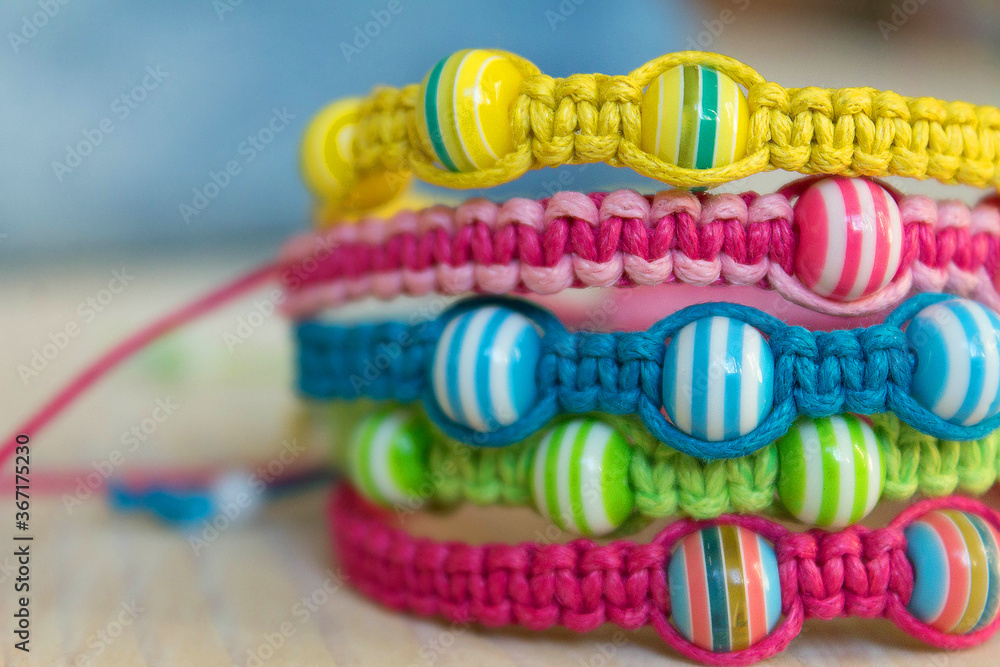 bright colored bracelets with striped beads close up
