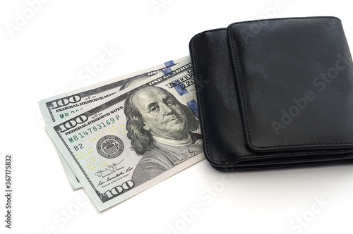 Two hundred dollar bills under a black leather wallet