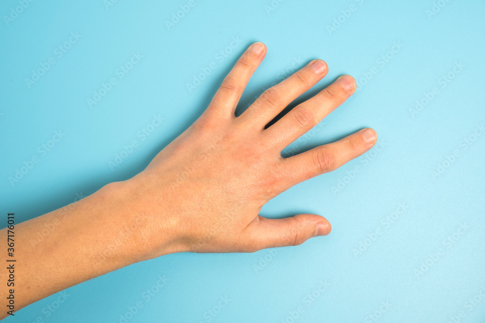 Close up of man's hand isolated on blue background Close up of man's hand isolated on blue background