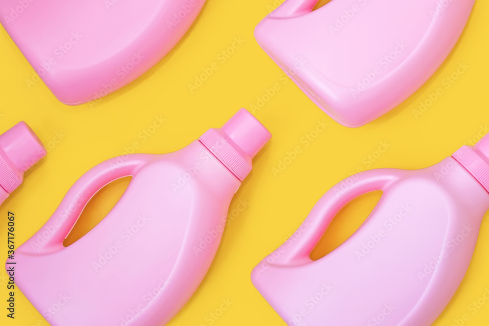 Pink bottles with chemicals for cleaning on a yellow background. Seamless pattern. Cleaning concept Pink bottles with chemicals for cleaning on a yellow background. Seamless pattern. Cleaning concept