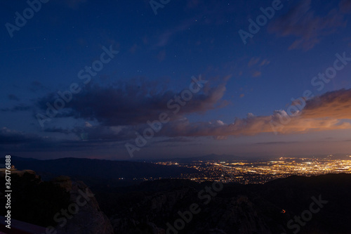 The city of Tucson  Arizona at dusk with clouds and stars