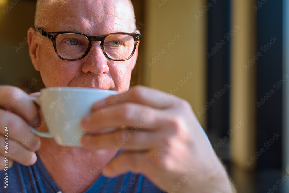 Senior handsome Scandinavian man relaxing inside the coffee shop Senior handsome Scandinavian man relaxing inside the coffee shop
