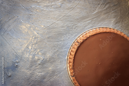 Top view of circle chocolate cake on grey background. Cake on corner with copy space.