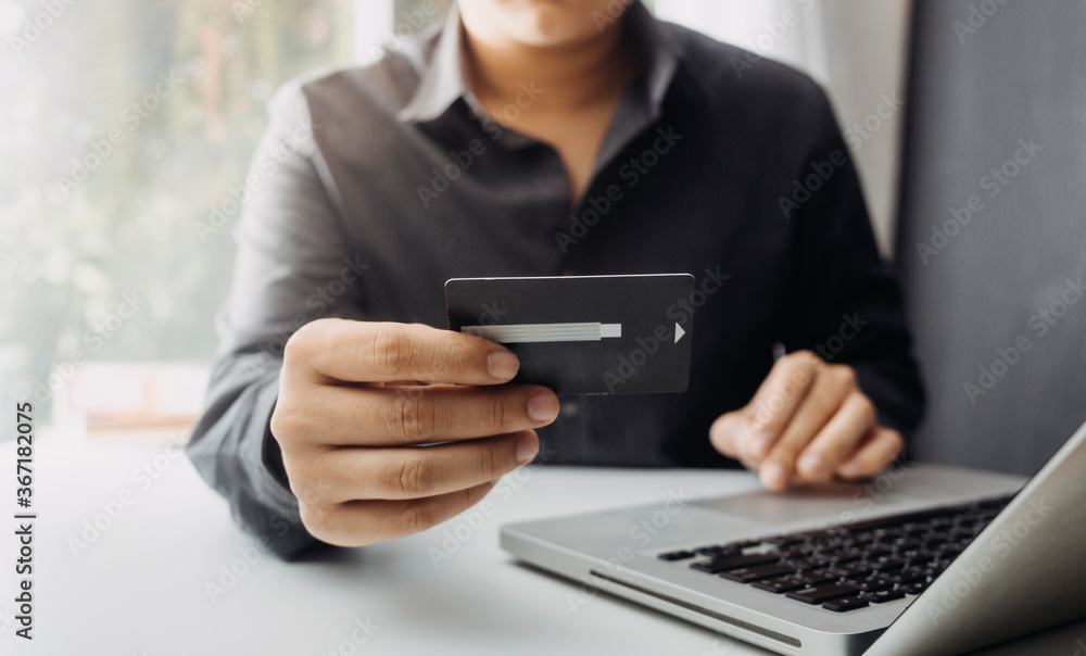 Business people use tablets and hold credit cards as an online shopping concept With a calculator and a book placed on the table Business people use tablets and hold credit cards as an online shopping concept With a calculator and a book placed on the table