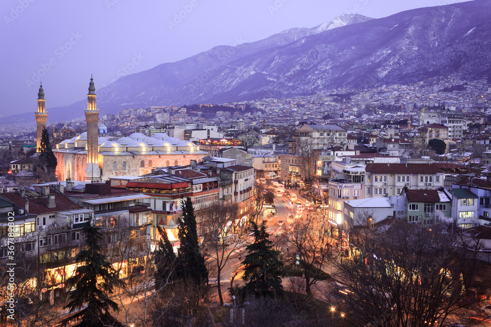 Historical Grand Mosque (Ulucami), Uludag with snow in winter and Bursa city night landscape from Bursa castle.