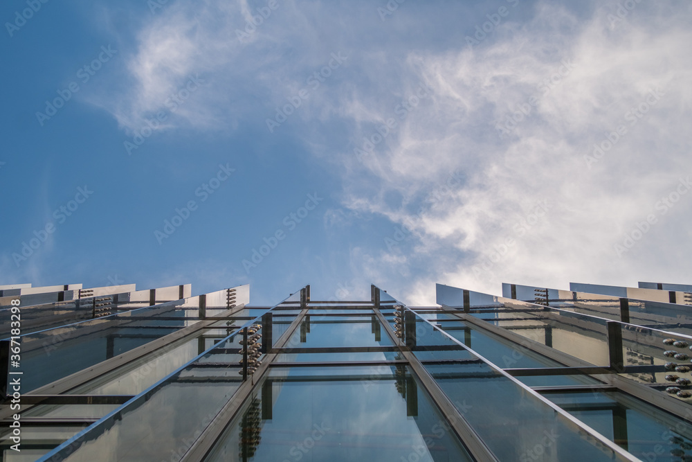 Modern glass facade office building against blue sky