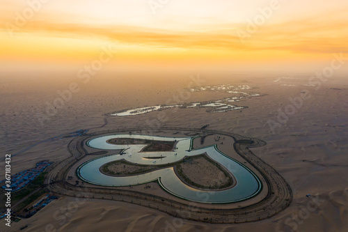 Fototapeta Naklejka Na Ścianę i Meble -  Beautiful sunset aerial View of Love Lake in Dubai located at Al Qudra. A new tourist destination near Qudra Lakes Dubai. Love Lake is one of the major tourist attraction in Dubai.