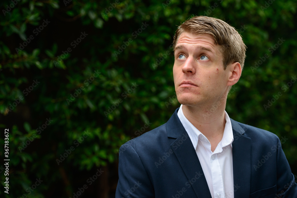 Young handsome businessman in suit thinking outdoors Young handsome businessman in suit thinking outdoors