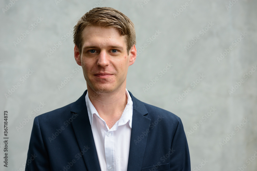 Young handsome businessman in suit against concrete wall outdoors Young handsome businessman in suit against concrete wall outdoors