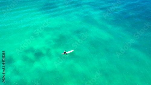 A photo of a surfer who is waiting in the ocean