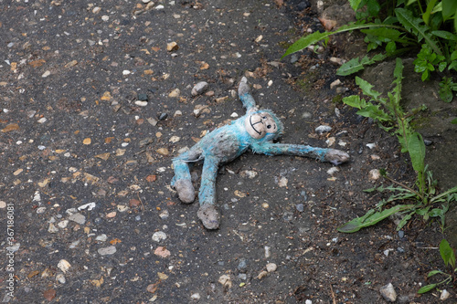 discarded child toy blue monkey lying on the road