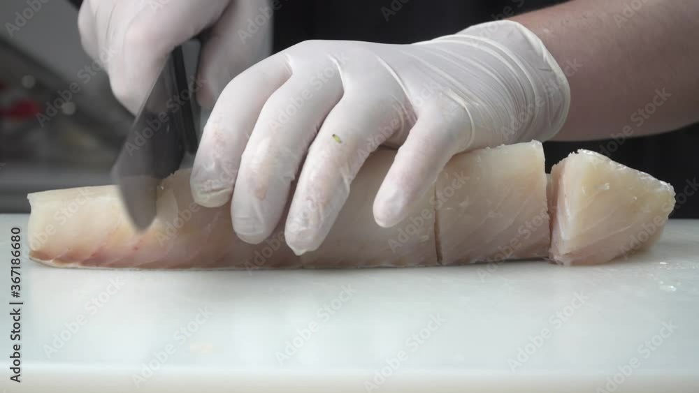 cortando pescado blanco encima de tabla de cortar en la cocina cortando pescado blanco encima de tabla de cortar en la cocina
