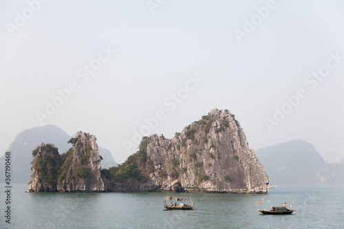 Ha Long Bay, Vietnam, limestone islands topped by rainforest with fishing boats