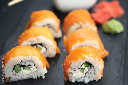 Sushi roll with salmon and lie on a black board made of slate stone