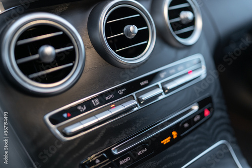 The center panel of the car interior with a view of the radio, air conditioning and other switches that make driving an elegant car more enjoyable. © Leszek