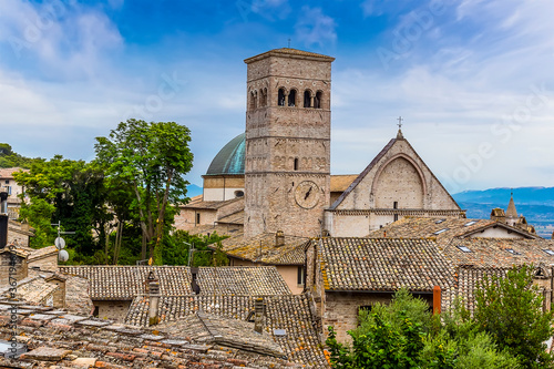 A view across the rooftops in Assisi, Umbria towards the cathedral of Saint Rufino in the summertime photo