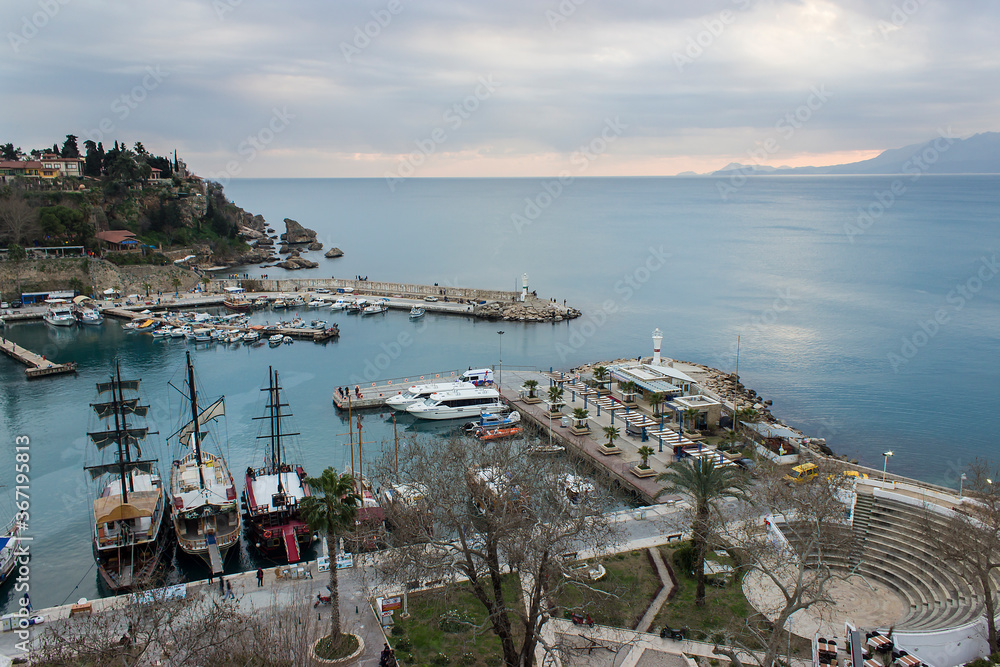 Old historical port of Antalya with anchored ship and boats in Mediterranean sea, Turkey.