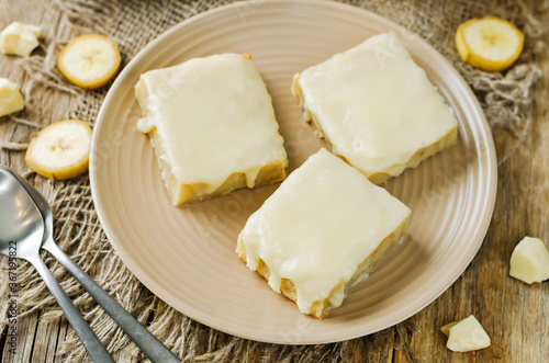White chocolate banana bars in a plate with glasses of coffee