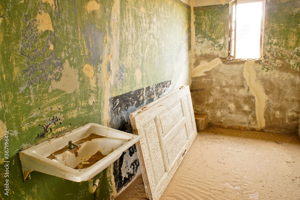 Drifting sand is slowly reclaiming old buildings in the abandoned mining town of Kolmannskuppe (Kolmanskop), Namibia Drifting sand is slowly reclaiming old buildings in the abandoned mining town of Kolmannskuppe (Kolmanskop), Namibia