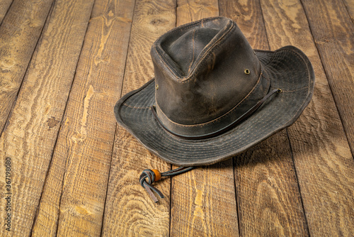 weathered outback oilskin hat  on rustic wooden table