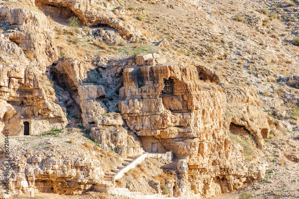 Monastic cave cells in mountain wall of the Kidron Stream. View from terrace of the Greek Orthodox Monastery Great Lavra St. Sabbas Sanctified (Mar Saba Monastery). Judean desert. Palestine, Israel.