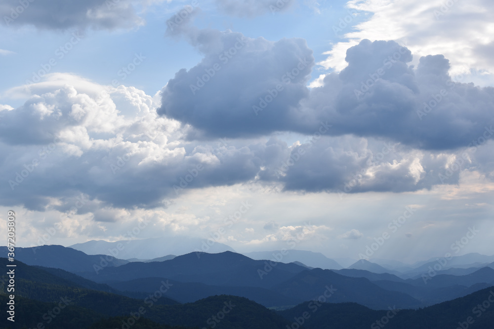 Berglandschaft mit dramatischen Wolken und blauem Himmel, Berge zum Horizont, farbschattierungen als Hintergrund, Urlaub zu Hause, daheim Urlaub machen in den Alpen, Gebirge