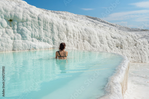 Fényképezés Woman in sunglasses bathing in travertine terraces pools in Pamukkale, Turkey