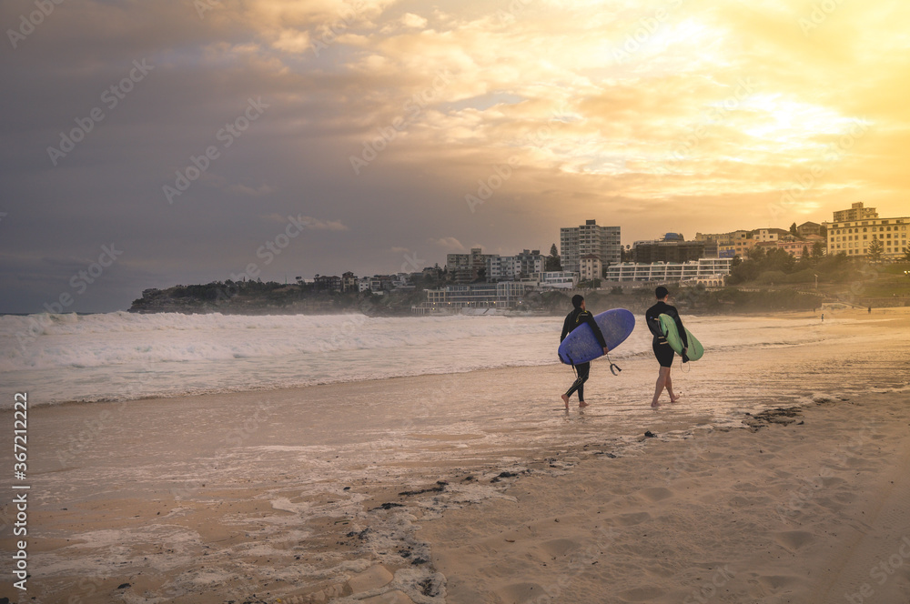 Fototapeta premium Sydney, NSW/Australia: Surfers leaving Bondi beach in the evening