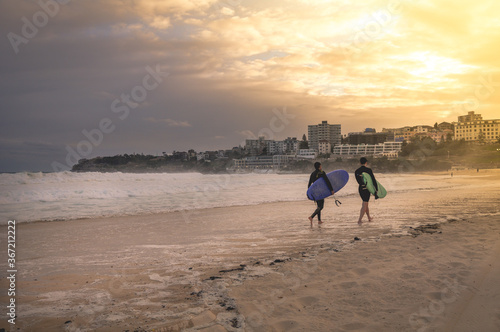 Sydney, NSW/Australia: Surfers leaving Bondi beach in the evening photo