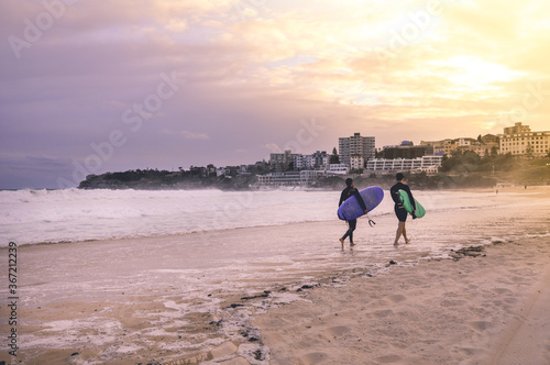 Sydney, NSW/Australia: Surfers leaving Bondi beach in the evening