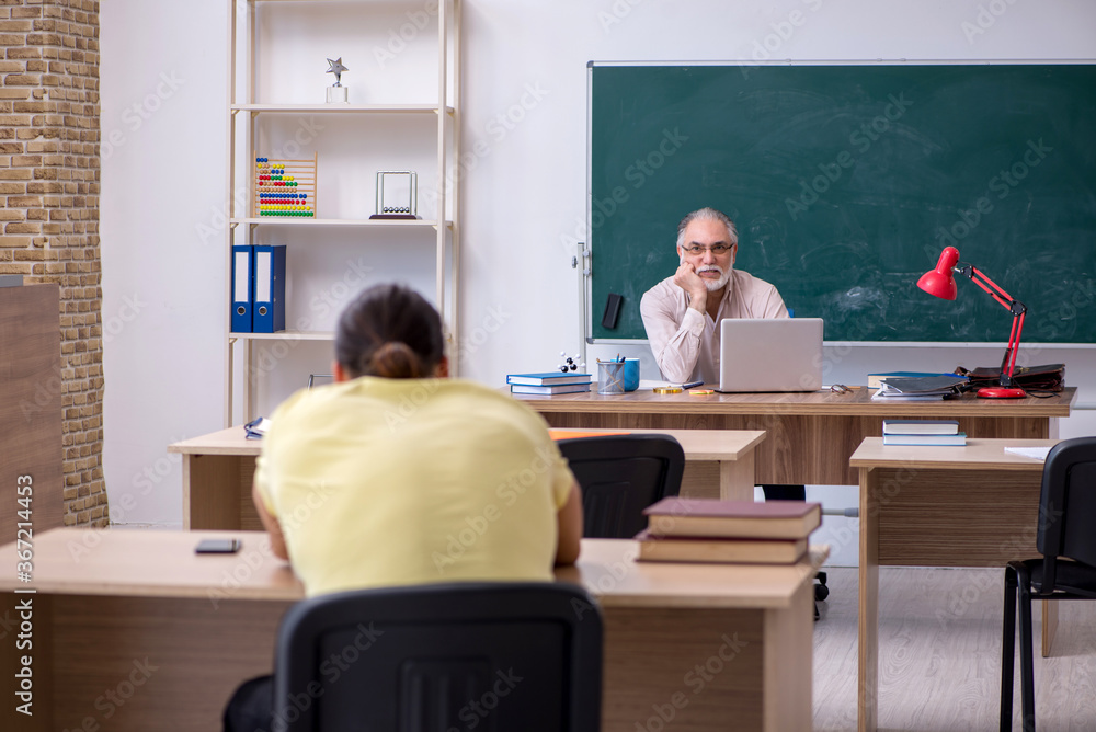 Old teacher and young male student in the classroom Old teacher and young male student in the classroom