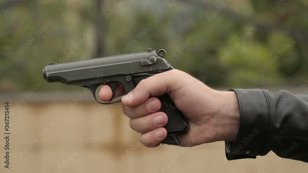 A man shoots a pistol with sparks, only the arm in the frame A man shoots a pistol with sparks, only the arm in the frame