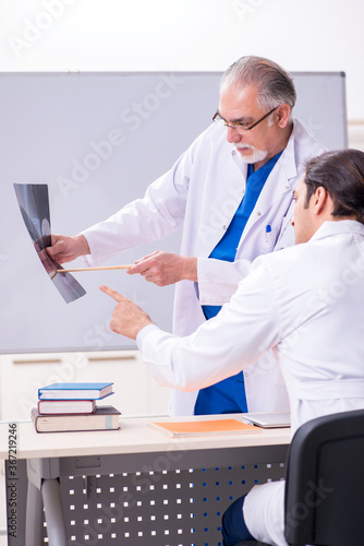 Wallpaper Mural Experienced doctor radiologist teaching young male assistant Torontodigital.ca