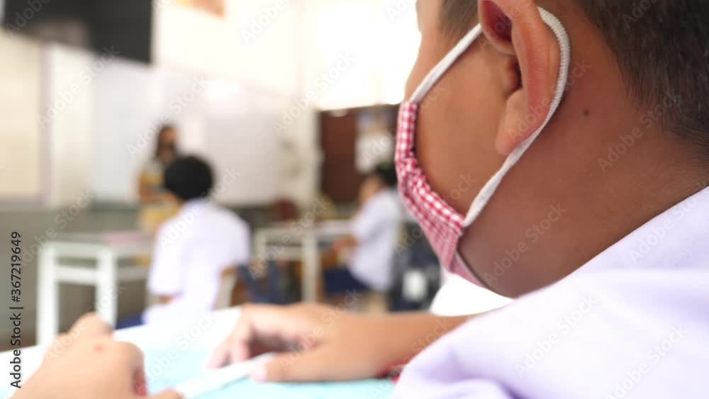 student wearing mask social distancing in classroom, education concept. student wearing mask social distancing in classroom, education concept.