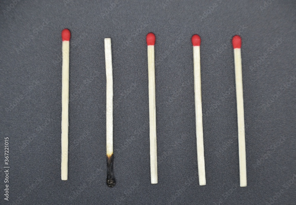 Matches with odd one out on a black background Matches with odd one out on a black background