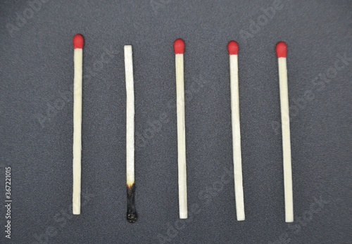 Matches with odd one out on a black background