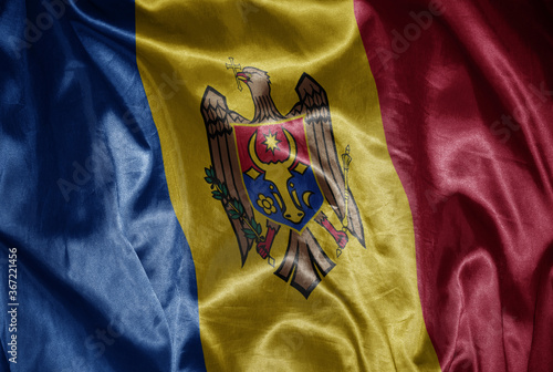 colorful shining big national flag of moldova on a silky texture.