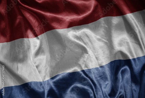 colorful shining big national flag of netherlands on a silky texture.