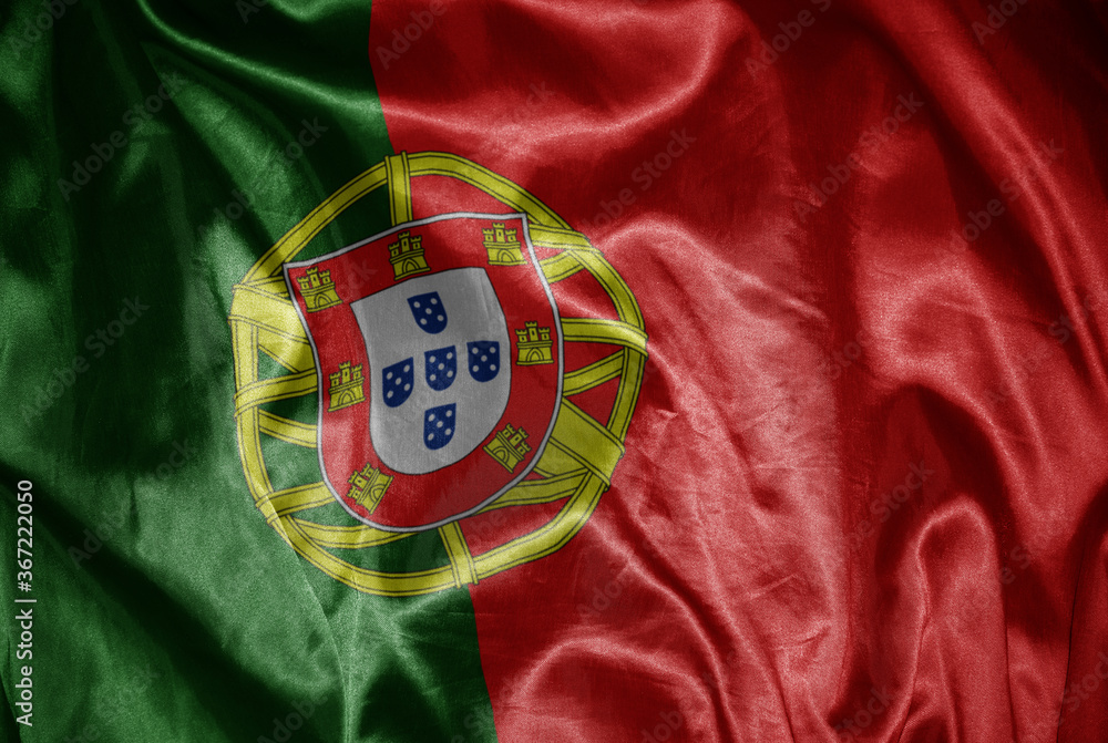 colorful shining big national flag of portugal on a silky texture.