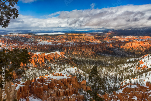 Beautiful view in Bryce Canyon National park in Utah. Orange rocks powdered with white snow makes landscape contrast and unusual 