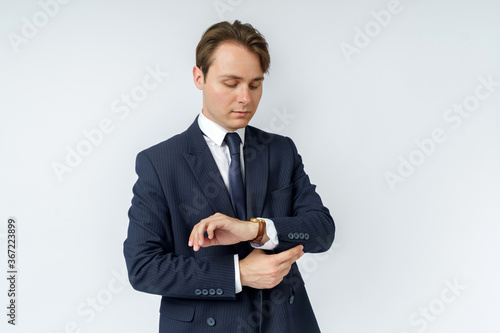 Portrait of a businessman in a blue suit straightening his suit. White background