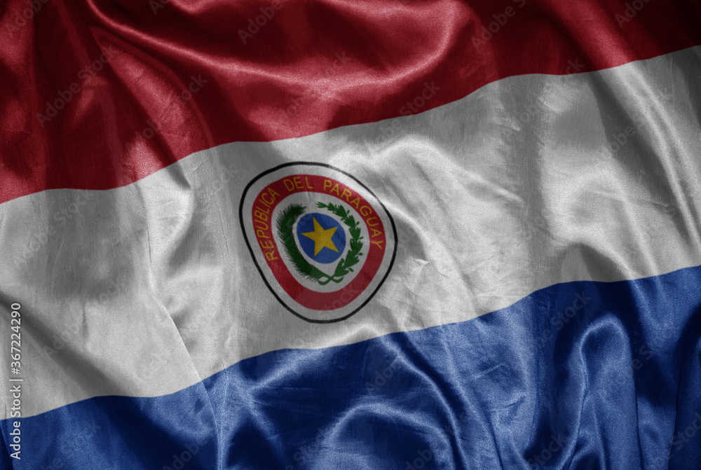 colorful shining big national flag of paraguay on a silky texture. colorful shining big national flag of paraguay on a silky texture.