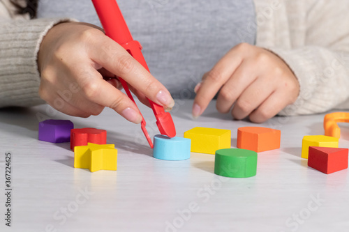 hand using tweezers with blocks