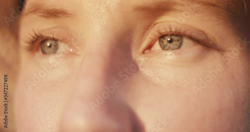 Close up portrait of a young gardener or farmer woman blue eye look at beautiful evening sunset sunlight golden light wear a hat macro slow motion