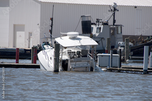 white power boat sinking in marina slip